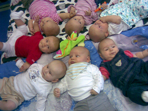 Sieben Babys liegen im Kreis
